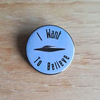 Pin badges and fridge magnets featuring a UFO and the words, I want to believe