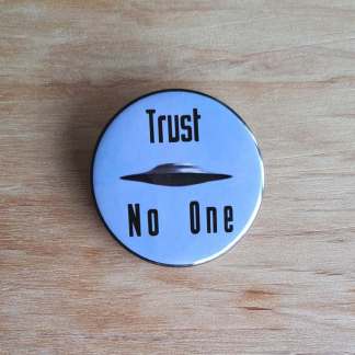 Pin badges and fridge magnets featuring a UFO and the words, Trust no one