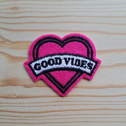 Heart shaped iron on patch with the words 'Good vibes'