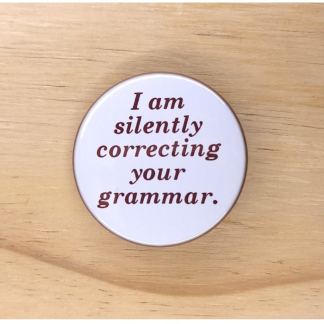 Pin badges and fridge magnets featuring the words, I am silently correcting your grammar