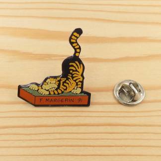 This enamel pin features a ginger tabby cat, created by the French comic book artist Frank Margerin